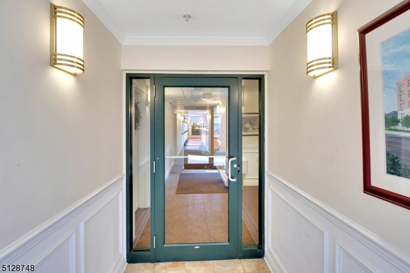 7 Prospect Street, Unit 303 Morristown, NJ 07960 - Photo 3 of 22 a view of a hallway view with wooden floor and living room