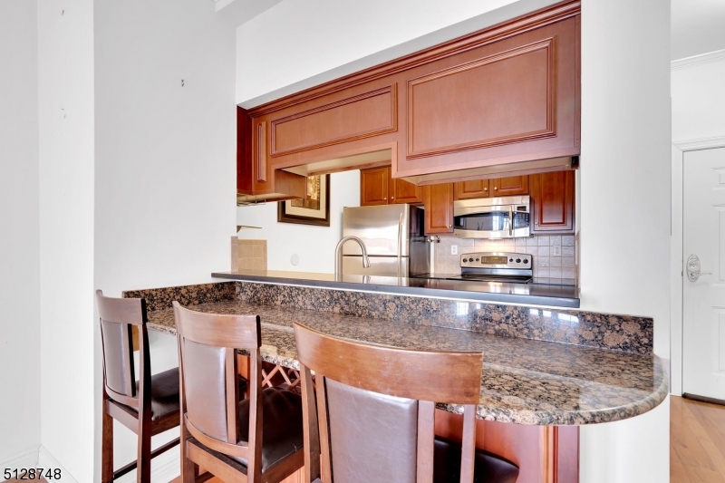 7 Prospect Street, Unit 303 Morristown, NJ 07960 - Photo 10 of 22 a kitchen with stainless steel appliances granite countertop a sink and a refrigerator