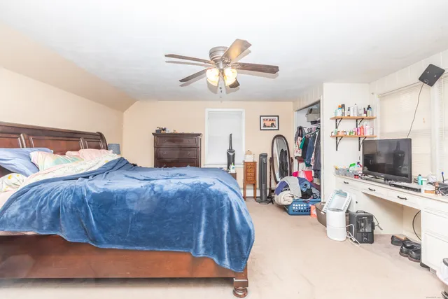 a bedroom with a bed and a flat tv screen