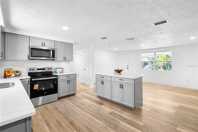 a kitchen with granite countertop a stove top oven sink and cabinets