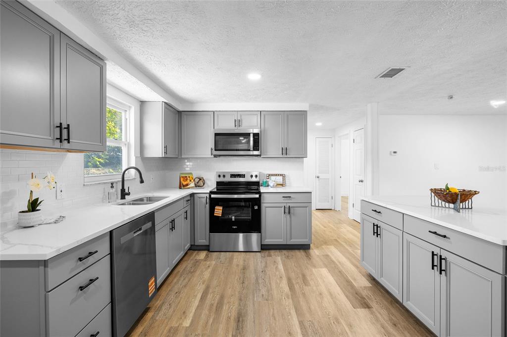 4244 Mesa Drive New Port Richey, FL 34653 - Photo 12 of 35 a kitchen with sink a microwave and cabinets
