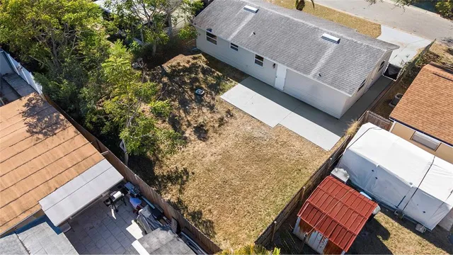 an aerial view of a house with a yard and large trees