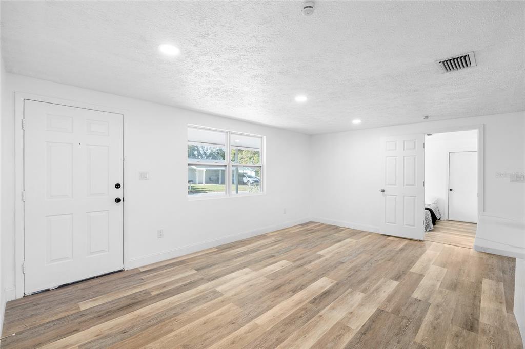 4244 Mesa Drive New Port Richey, FL 34653 - Photo 6 of 35 a view of an empty room with wooden floor and a window