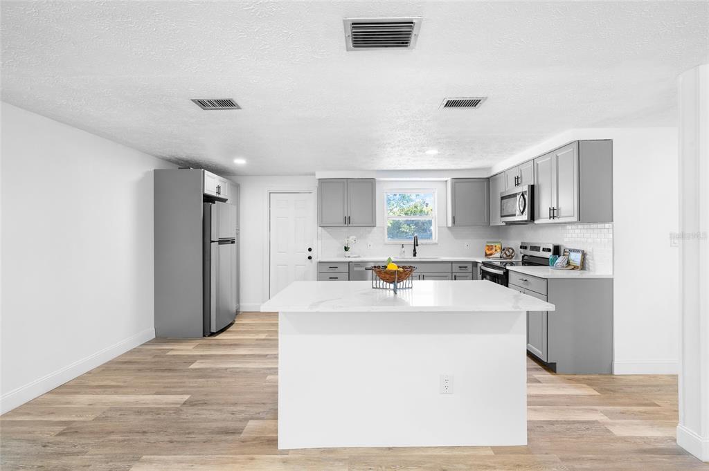 4244 Mesa Drive New Port Richey, FL 34653 - Photo 9 of 35 a kitchen with sink cabinets and refrigerator