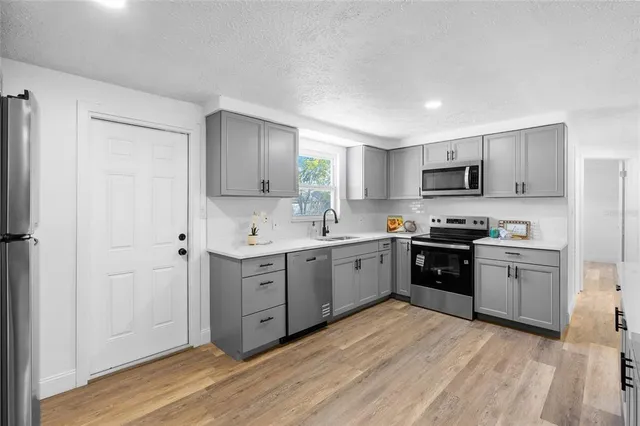 a kitchen with stainless steel appliances granite countertop a stove a sink and a refrigerator