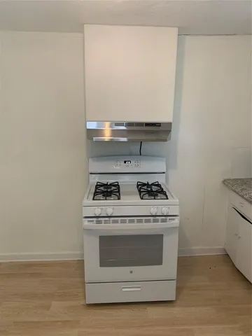 a stove top oven sitting inside of a kitchen