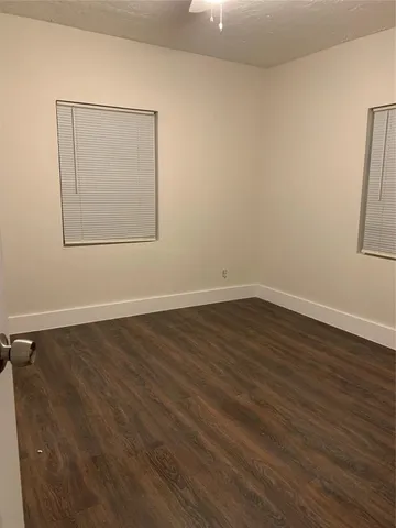 a view of a room with wooden floor and white walls