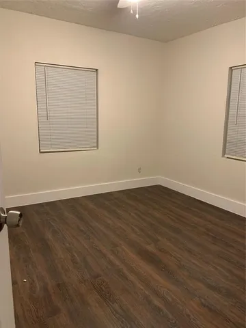 a view of a room with wooden floor and white walls
