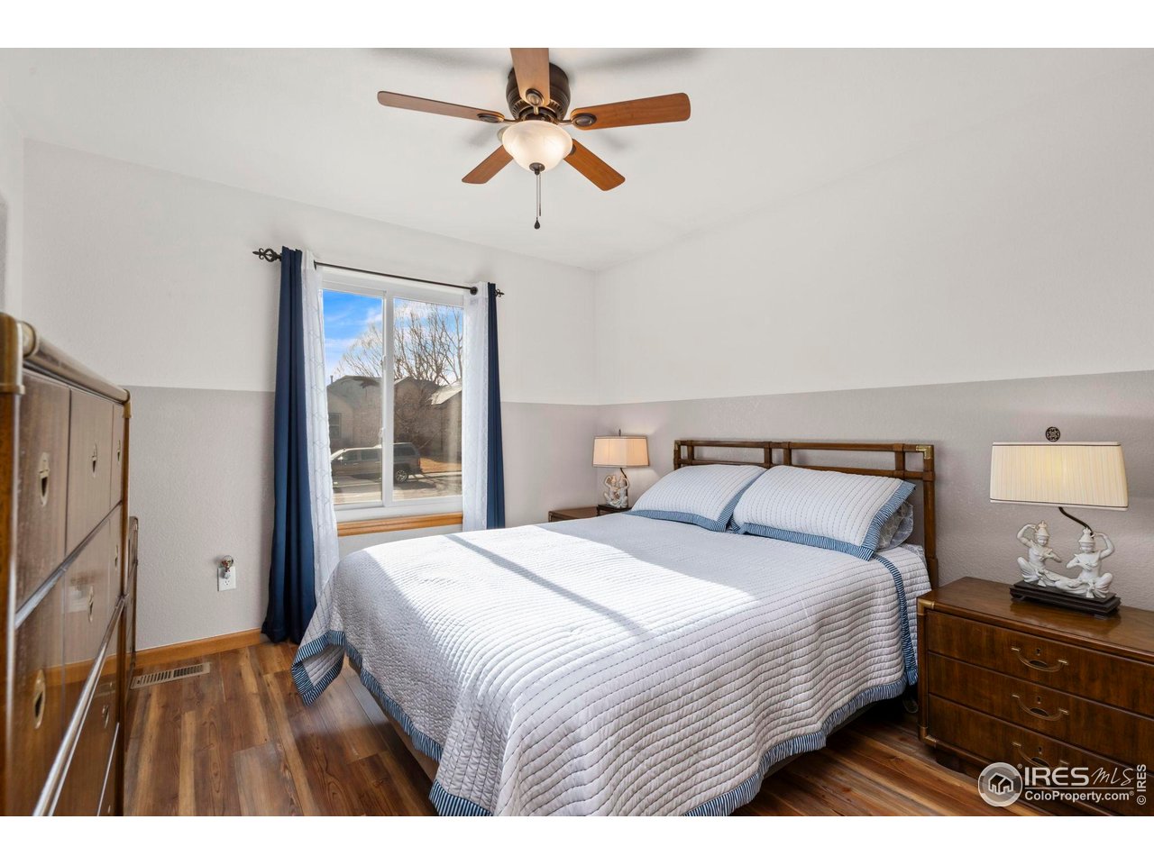 3012 54th Avenue Greeley, CO 80634 - Photo 21 of 33 a bedroom with a large bed and a chandelier