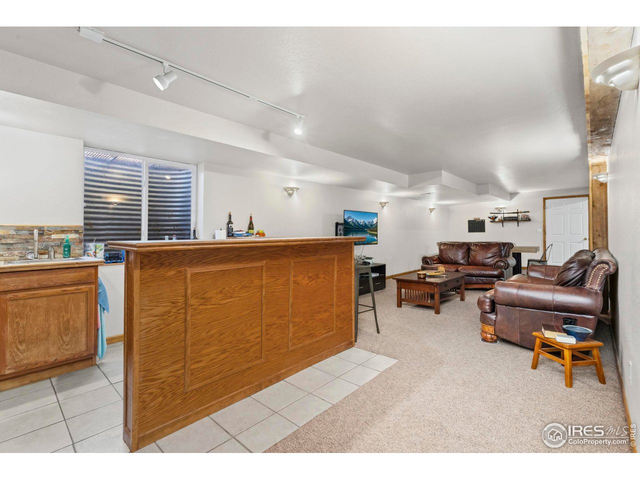 3012 54th Avenue Greeley, CO 80634 - Photo 22 of 33 a living room with furniture a window and a wooden floor