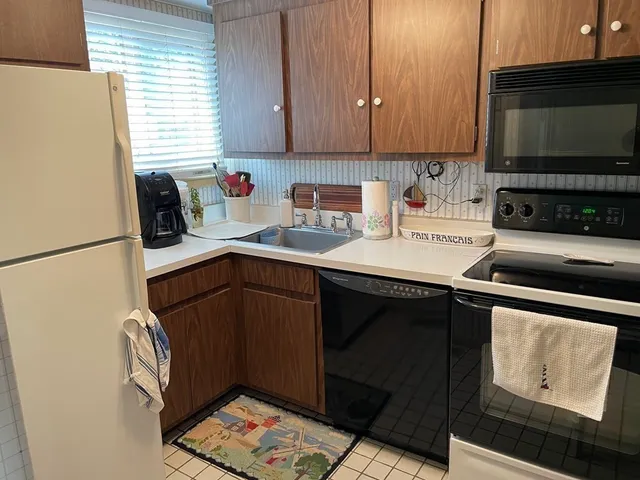 a kitchen with stainless steel appliances a stove a sink a refrigerator and cabinets