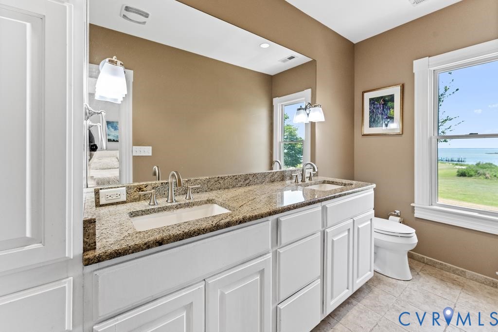 2414 Windmill Point Road White Stone, VA 22578 - Photo 29 of 72 a bathroom with a granite countertop toilet sink and mirror
