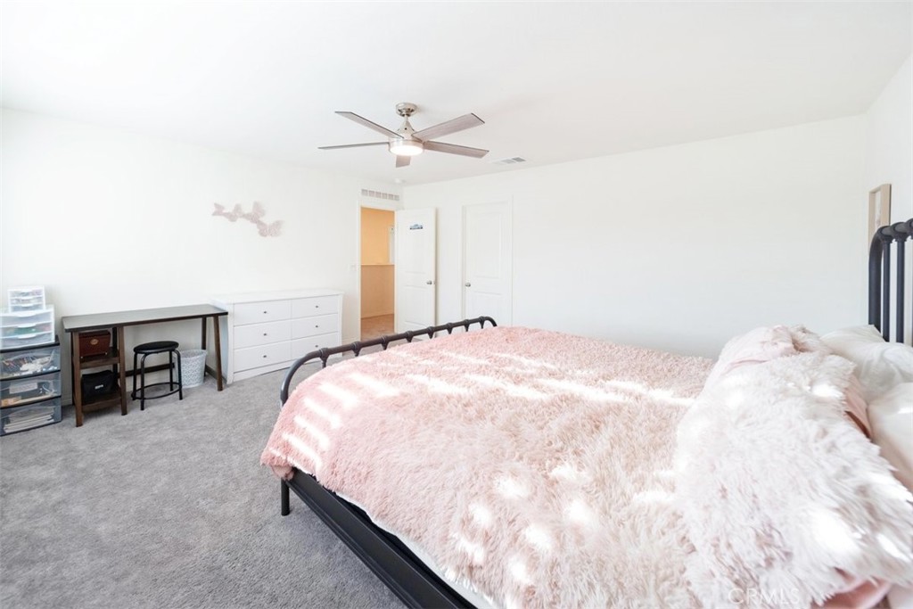 32078 Rambling Court Winchester, CA 92596 - Photo 32 of 48 a bedroom with a bed and a chandelier