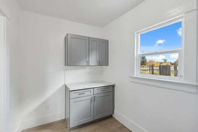 a view of a kitchen with white cabinets and wooden floor