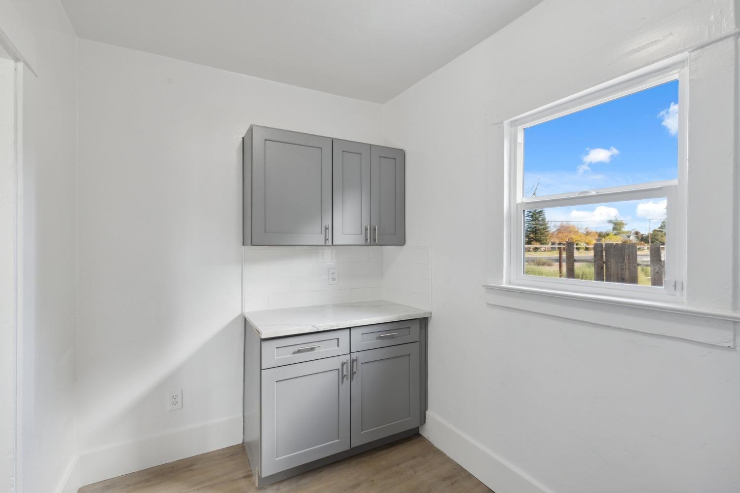 1515 North Fruit Avenue Fresno, CA 93728 - Photo 19 of 23 a view of a kitchen with white cabinets and wooden floor