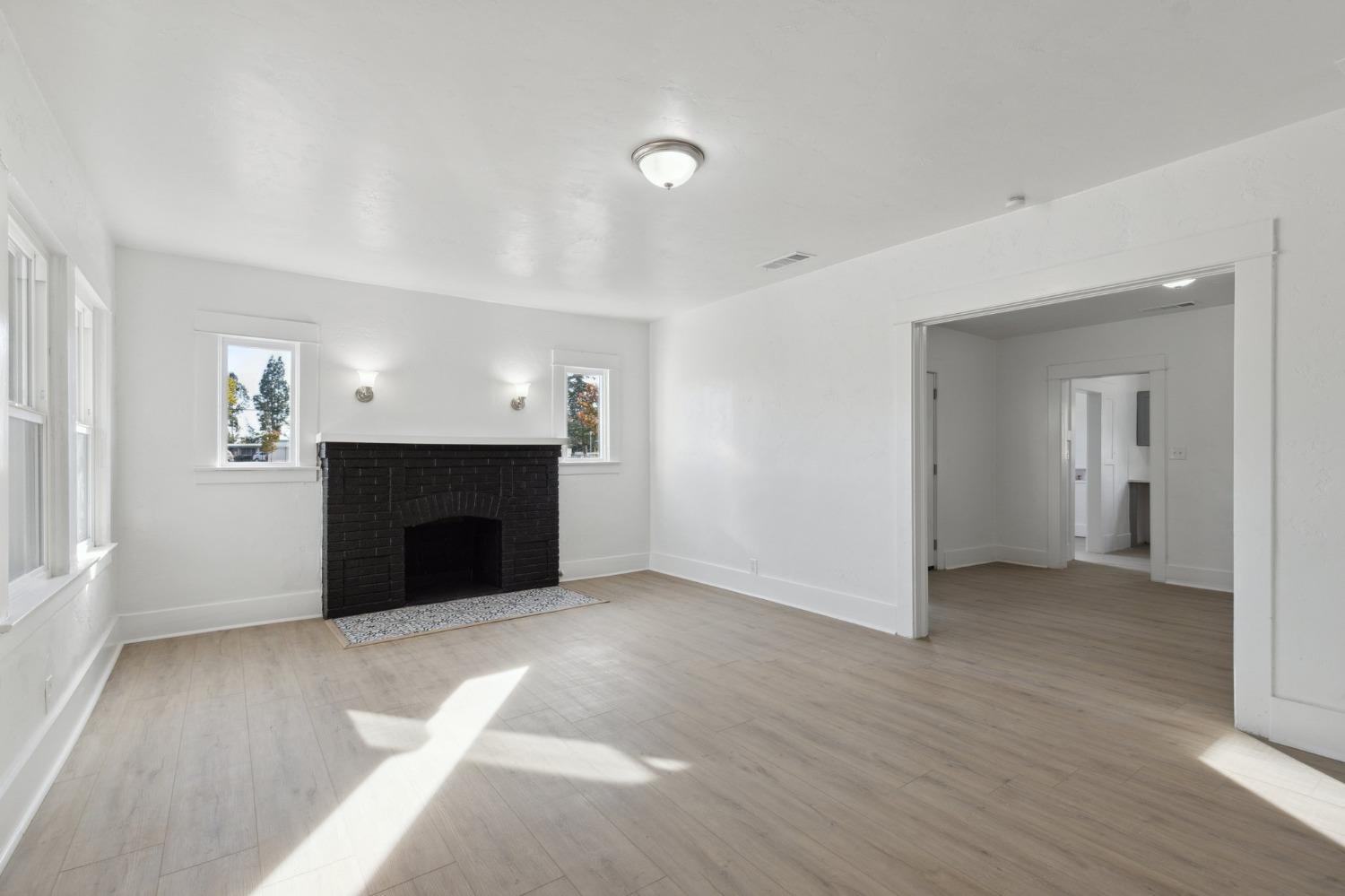 1515 North Fruit Avenue Fresno, CA 93728 - Photo 4 of 23 an empty room with wooden floor and fireplace