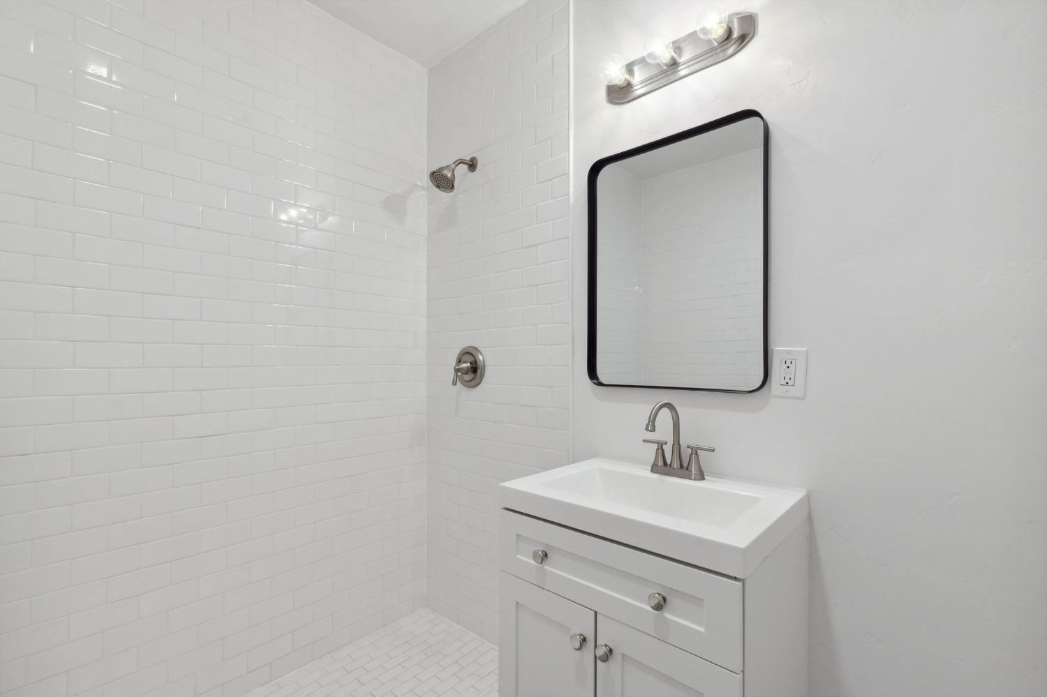 1515 North Fruit Avenue Fresno, CA 93728 - Photo 9 of 23 a bathroom with a sink a vanity and a mirror