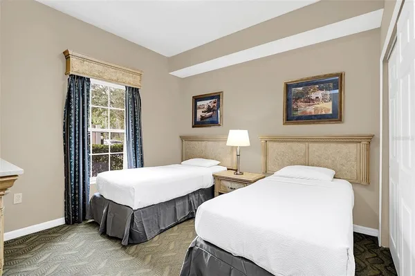 a spacious bedroom with two beds and a window