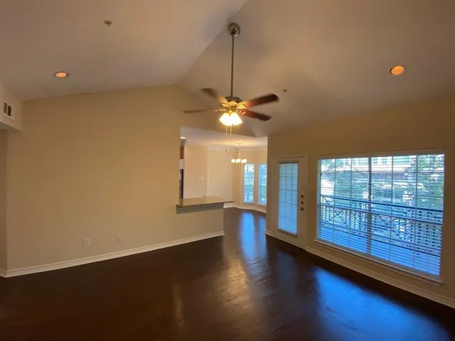 a view of a livingroom with wooden floor and a large window