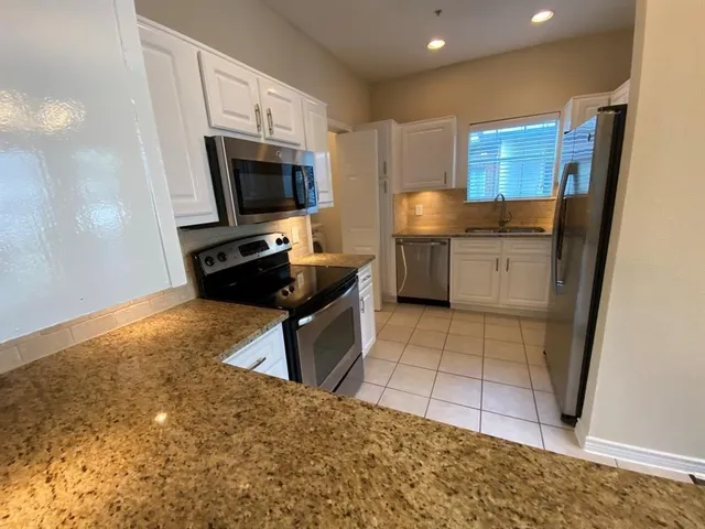 a kitchen with stainless steel appliances a stove a sink and a refrigerator