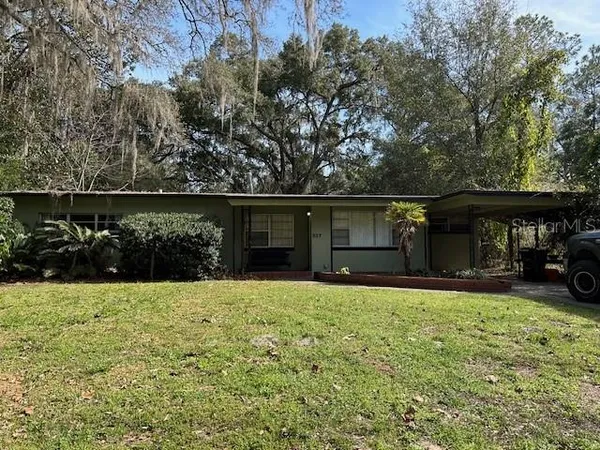 a view of a house with a yard and sitting area