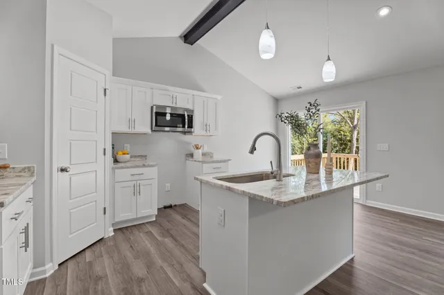 a kitchen with sink a microwave and cabinets