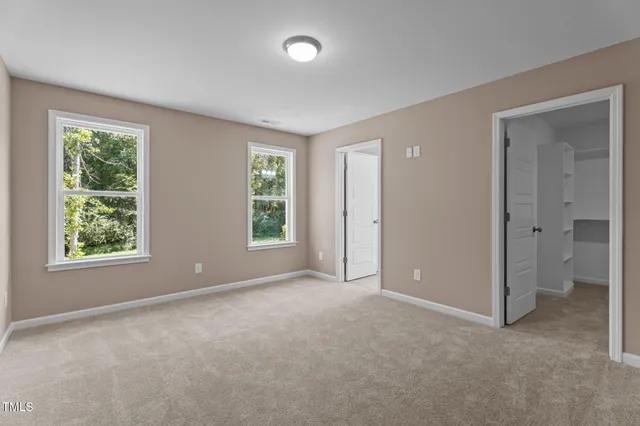 an empty room with windows and closet