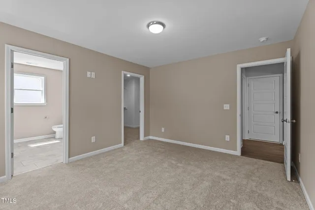 a view of an empty room and a bathroom