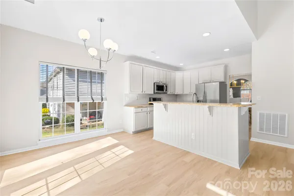 a kitchen with kitchen island granite countertop a stove top oven a sink and dishwasher