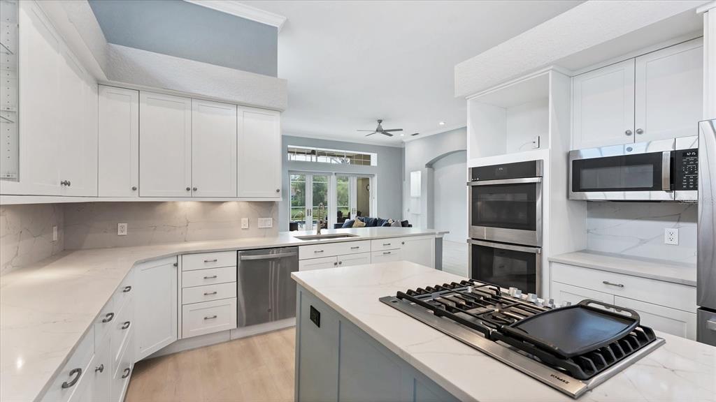 7217 Churston Lane University Park, FL 34201 - Photo 14 of 60 a kitchen with white cabinets and stainless steel appliances