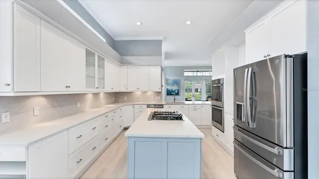 a kitchen with a refrigerator sink and cabinets