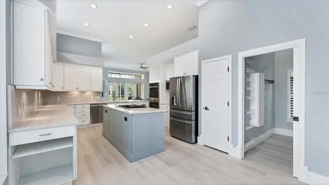 a kitchen with granite countertop a stove and a white cabinets