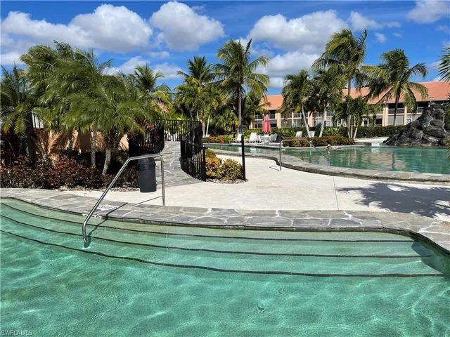 a view of swimming pool with a bench and trees around