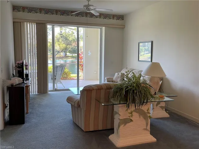 a living room with furniture and a floor to ceiling window