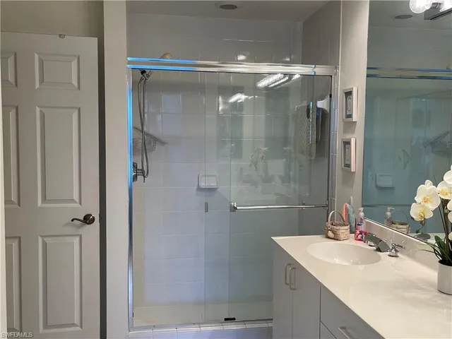 a bathroom with a shower sink vanity and mirror