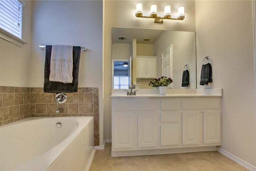 1900 Scofield Ridge Parkway, Unit 4801 Austin, TX 78727 - Photo 11 of 15 a bathroom with a bathtub a double vanity sink and a mirror