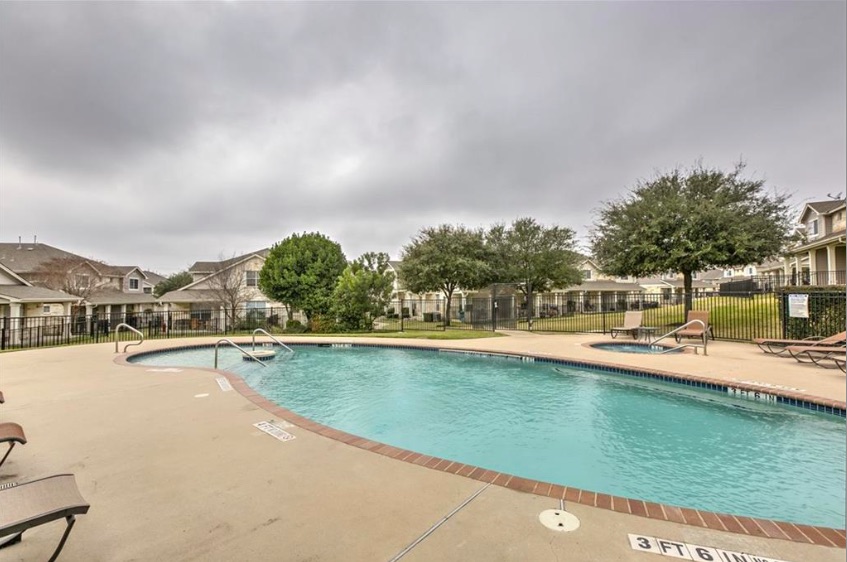 1900 Scofield Ridge Parkway, Unit 4801 Austin, TX 78727 - Photo 7 of 15 a view of a swimming pool with a lawn chairs under an umbrella