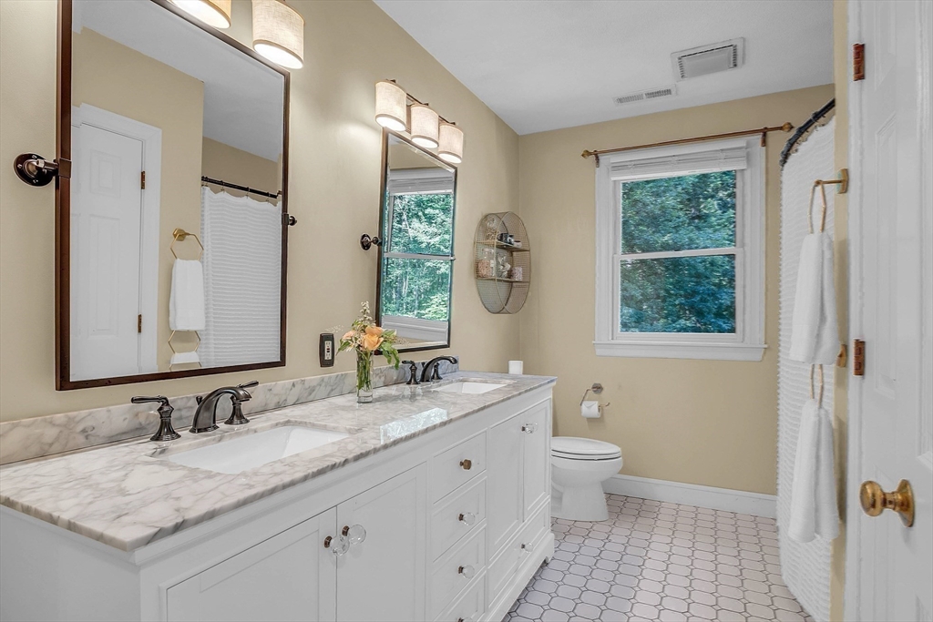 157 Lancaster Road North Andover, MA 01845 - Photo 29 of 42 a bathroom with a granite countertop sink a toilet a large mirror and a window