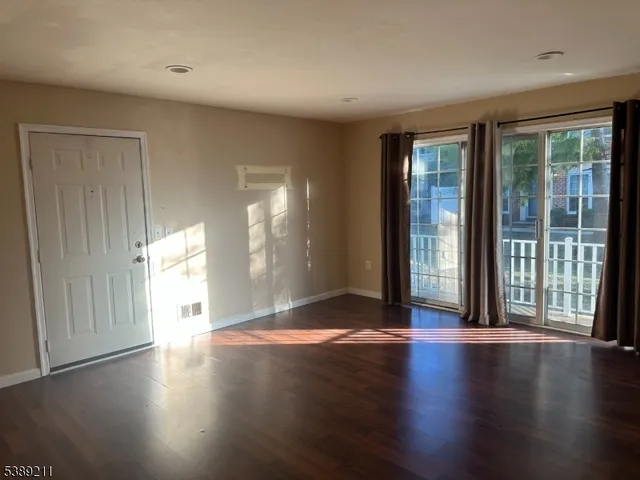 a view of a big room with wooden floor and windows