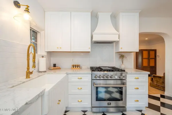 a kitchen with stainless steel appliances white cabinets and a stove top oven