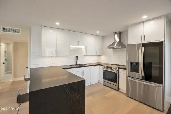 a kitchen with stainless steel appliances a refrigerator sink and stove