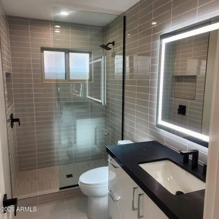 a bathroom with a sink a toilet and shower
