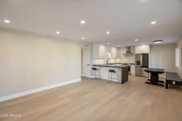 a large kitchen with stainless steel appliances a large counter top a stove and a refrigerator