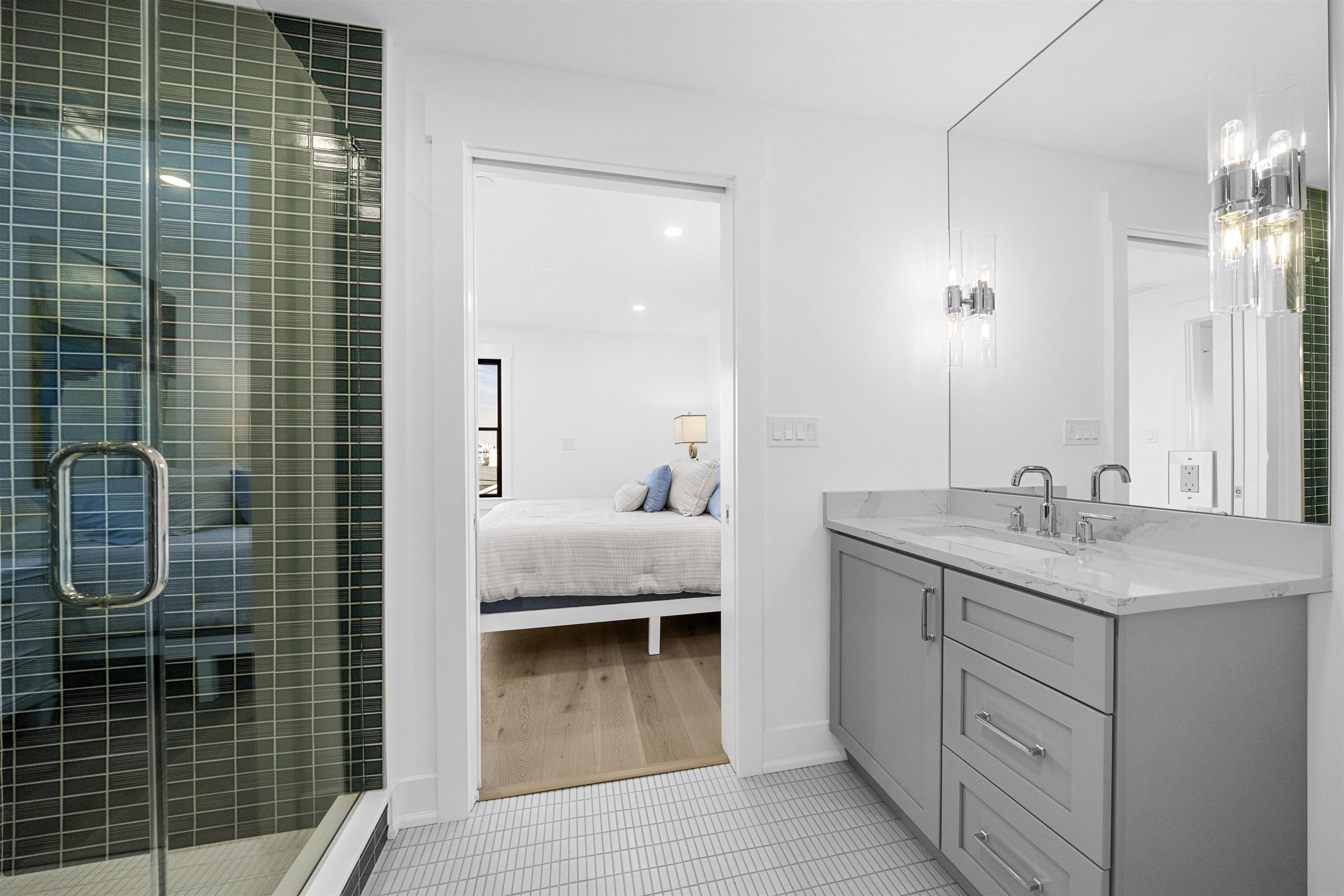 2927 Dune, Unit 1 Avalon, NJ 08202 - Photo 21 of 35 a en suite bathroom with a granite countertop sink a toilet a mirror and shower