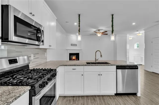 a kitchen with granite countertop a stove a sink and a microwave