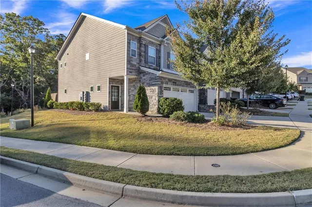 a view of a white house with a yard and large tree