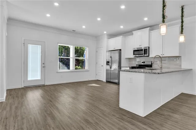 a kitchen with kitchen island granite countertop a stove a sink a refrigerator and a microwave