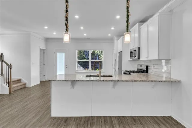 a large kitchen with granite countertop a sink a window and stainless steel appliances