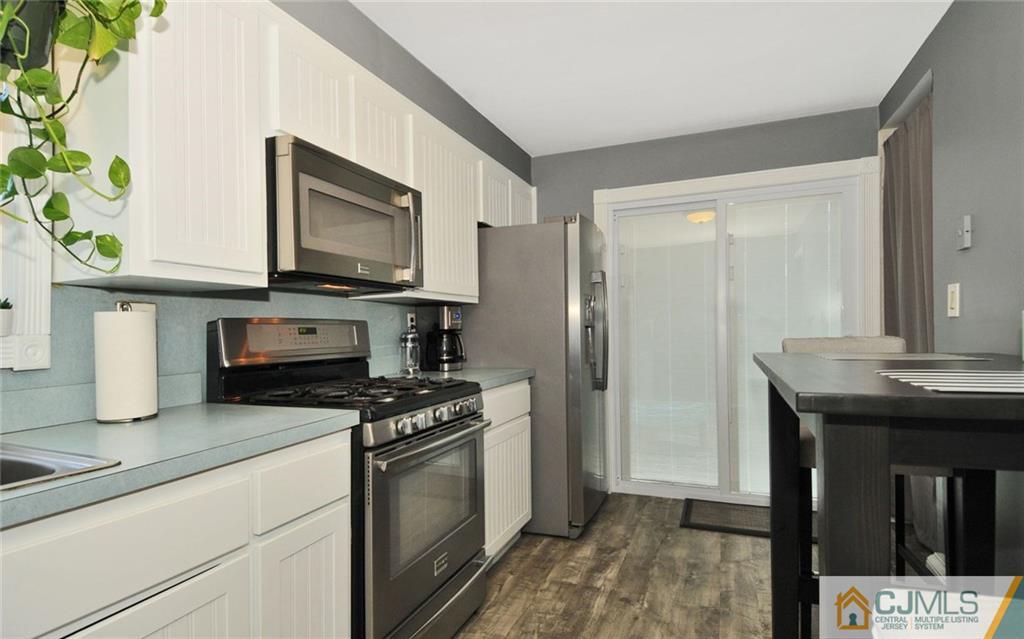 156 Tunison Road New Brunswick, NJ 08901 - Photo 5 of 25 a kitchen with stainless steel appliances a stove a microwave a sink and cabinets
