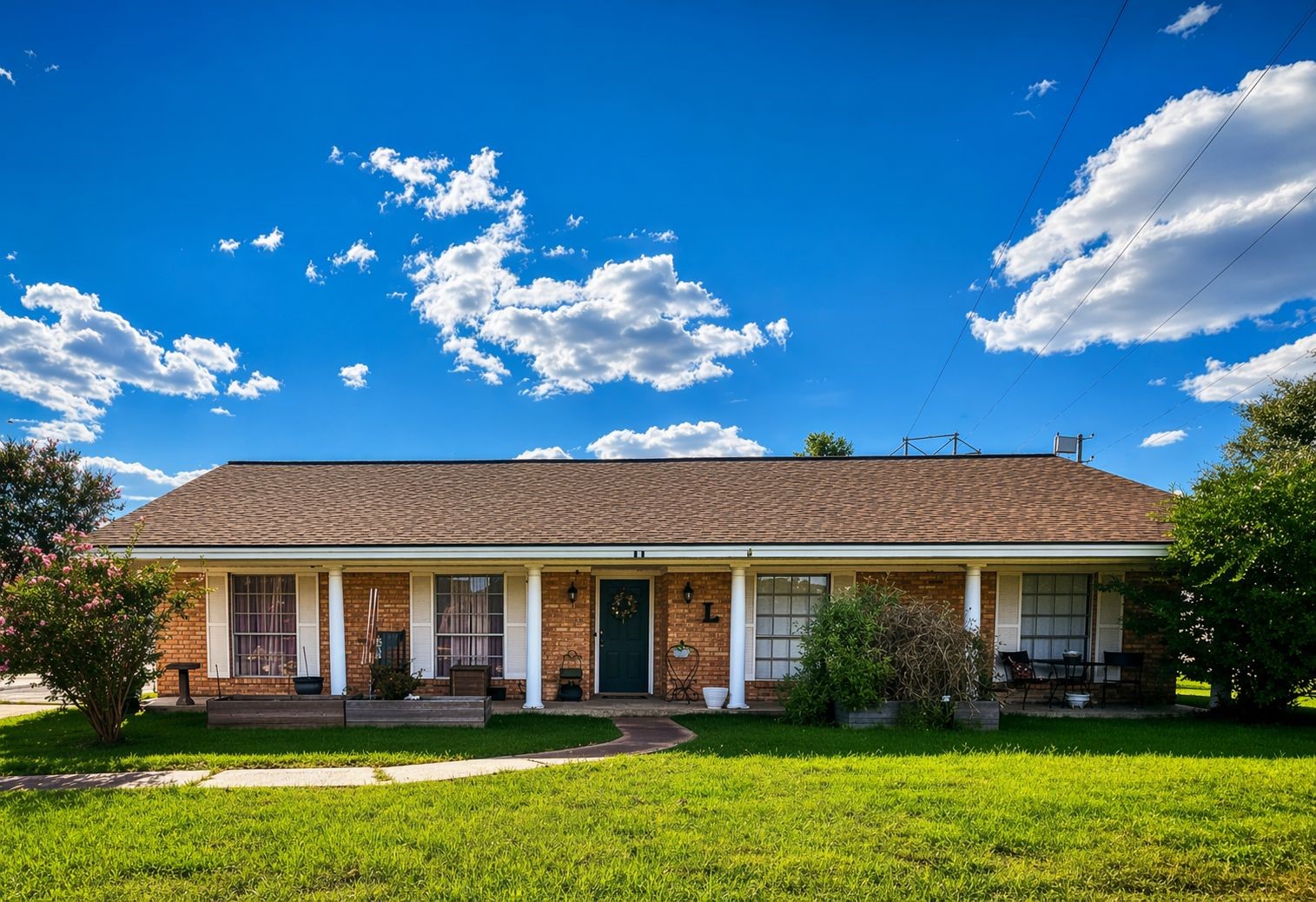 a front view of a house with a yard and potted plants